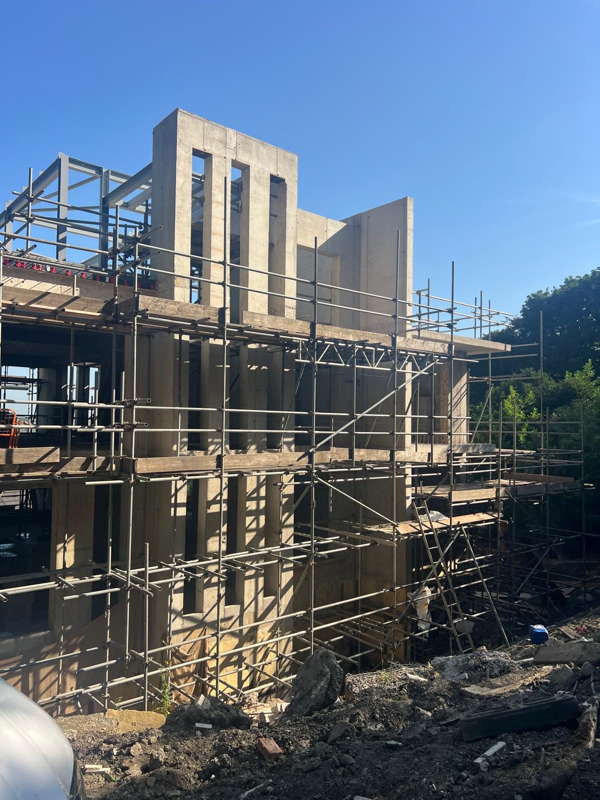 In-situ concrete walls and cores rising through the scaffold