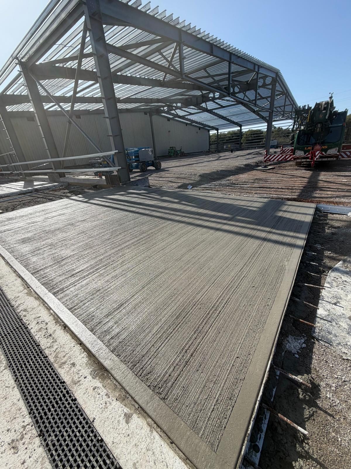 Textured slab and drainage channel under a new canopy frame