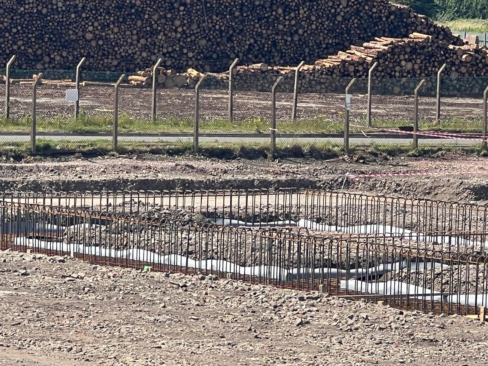 Ground beam reinforcement in front of stacked timber