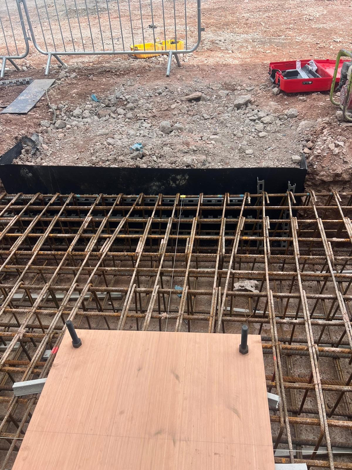 Pad reinforcement with holding down bolts set through a template