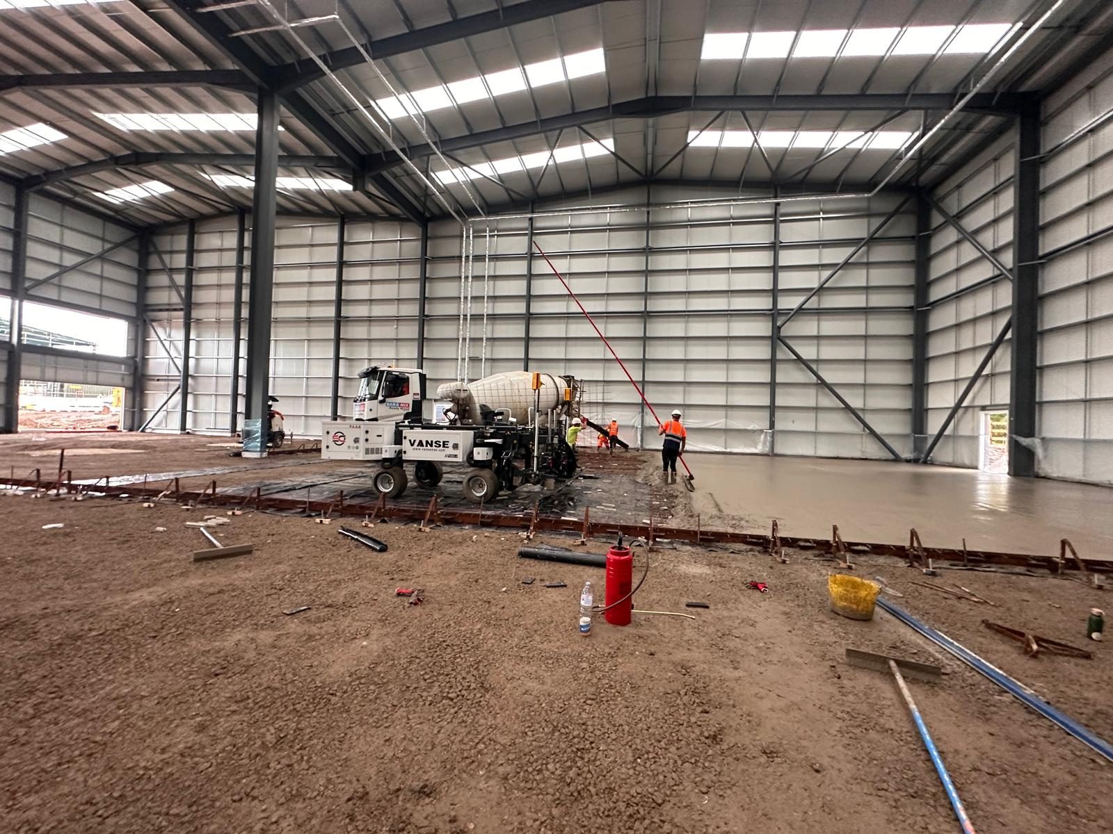 Vanse machine with mixing drum placing concrete inside a warehouse