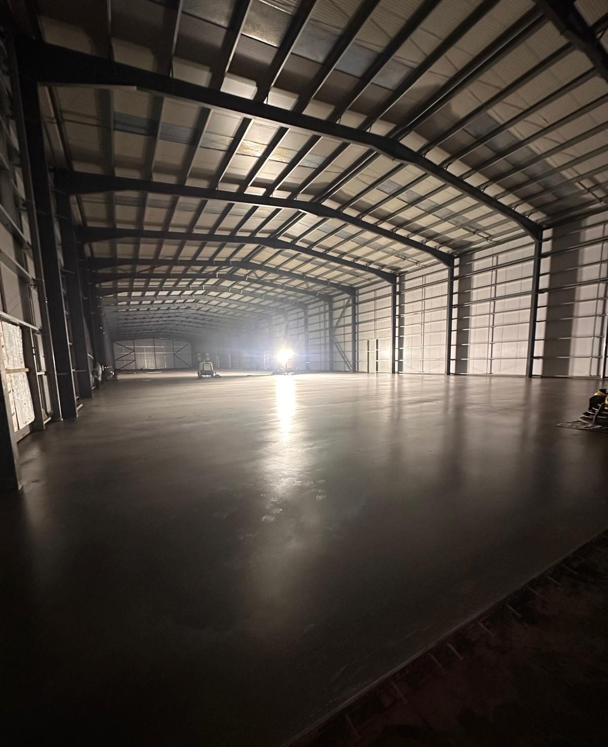 Finished concrete floor inside a large steel framed building